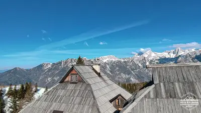 a roof of a building with mountains in the background at Chalet Gorenjka - Velika planina in Stahovica