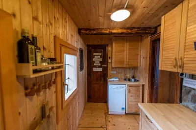a kitchen with wooden walls and a white refrigerator at Chalet Gorenjka - Velika planina in Stahovica