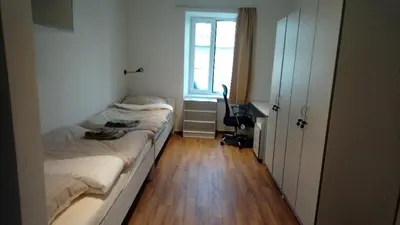 a small bedroom with two beds and a window at Bajta na obzidju in Maribor