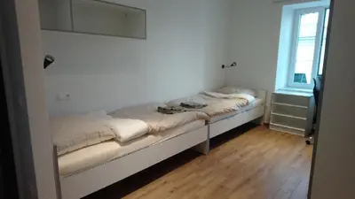 a small bed in a room with a window at Bajta na obzidju in Maribor