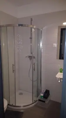 a glass shower in a bathroom with a toilet at Bajta na obzidju in Maribor