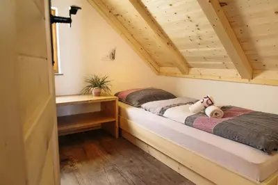 a bedroom with two beds in a wooden cabin at Holiday house Jereka -Bohinj in Bohinj
