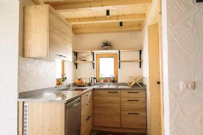a small kitchen with wooden cabinets and a sink at Holiday house Jereka -Bohinj in Bohinj