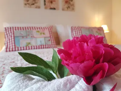 a pink flower sitting on top of a bed at Apartment Eden Bled in Bled