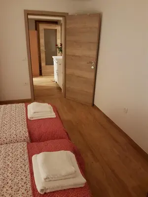 a bedroom with two beds and a hallway with a mirror at Apartment Eden Bled in Bled