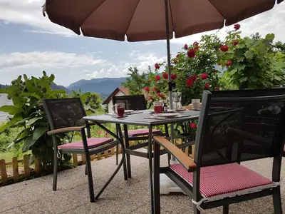 a table and chairs under an umbrella on a patio at Apartment Eden Bled in Bled