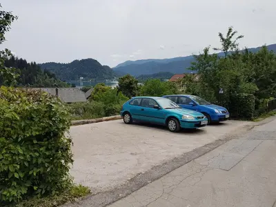 two blue cars parked in a parking lot at Apartment Eden Bled in Bled