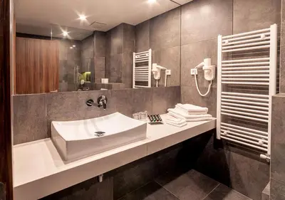 a bathroom with a sink and a mirror at Atelier Hotel in Ljubljana