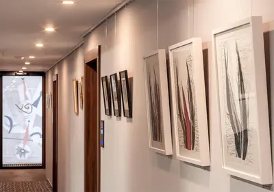 a row of framed drawings on a wall at Atelier Hotel in Ljubljana