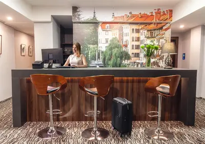 a woman sitting at a counter in an office at Atelier Hotel in Ljubljana