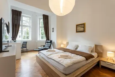 a bedroom with a large bed and two chairs at Urban Rooms--free parking-- in Ljubljana