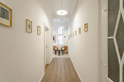 a hallway leading to a dining room with paintings on the walls at Urban Rooms--free parking-- in Ljubljana