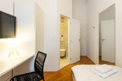 a room with a bed and a television and a bathroom at Urban Rooms--free parking-- in Ljubljana