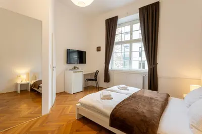 a bedroom with a bed and a tv and a window at Urban Rooms--free parking-- in Ljubljana
