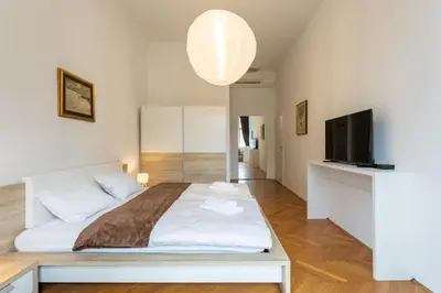 a bedroom with a large bed and a flat screen tv at Urban Rooms--free parking-- in Ljubljana