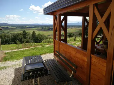 a bench with a grill on top of a hill at Apartment Countryside Kolpa-Bela krajina in Metlika