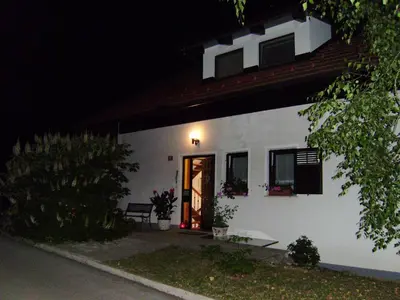 a white house with a door at night at Apartment Countryside Kolpa-Bela krajina in Metlika