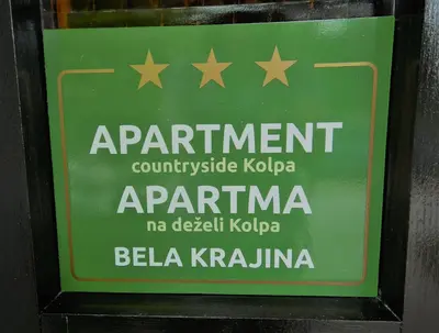 a green sign with stars on the side of a building at Apartment Countryside Kolpa-Bela krajina in Metlika