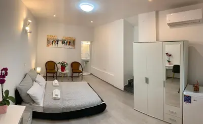 a bedroom with a bed and a living room at Lina Rooms Hostel in Ljubljana