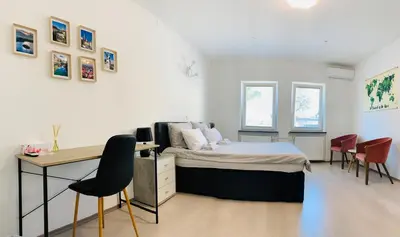 a bedroom with a bed and a desk and chairs at Lina Rooms Hostel in Ljubljana