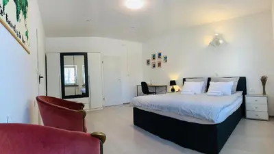 a bedroom with a king sized bed and a chair at Lina Rooms Hostel in Ljubljana