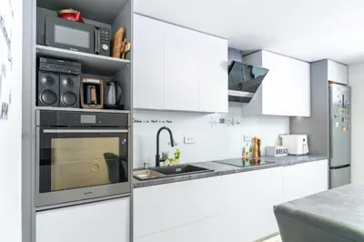 a kitchen with white cabinets and a stove top oven at Apartmaji pri Jožu in Bohinj