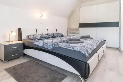 a bedroom with a large bed and a dresser at Apartmaji pri Jožu in Bohinj