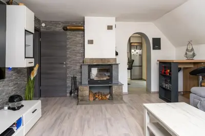 a living room with a fireplace in the middle at Apartmaji pri Jožu in Bohinj