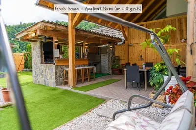 an outdoor kitchen with a wooden pergola at Apartmaji pri Jožu in Bohinj