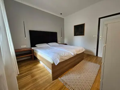 a bedroom with a large bed with a wooden floor at Hotel Sporn in Radomlje