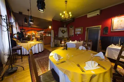 a dining room with two tables with yellow table cloth at Hotel Sporn in Radomlje