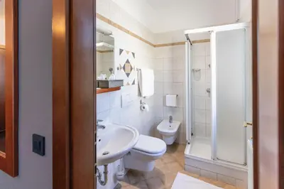 a white bathroom with a toilet and a sink at Hotel Sporn in Radomlje