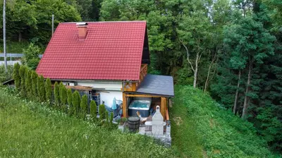 a small house with a red roof on a hill at House Franja in Kranjska Gora
