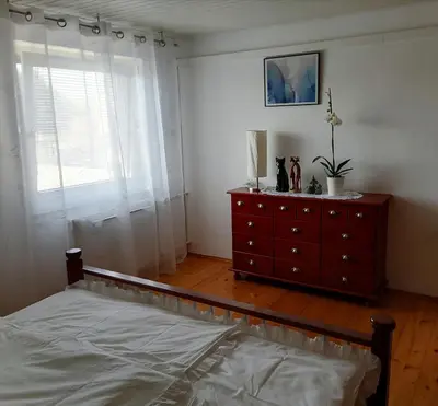 a bedroom with a bed and a dresser and a window at at Marian's place in Spuhlja