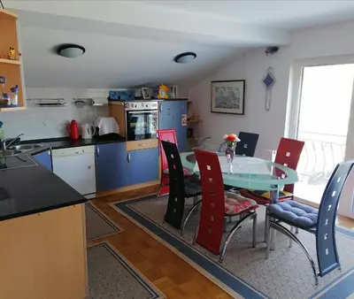 a kitchen with a table and chairs in a room at at Marian's place in Spuhlja