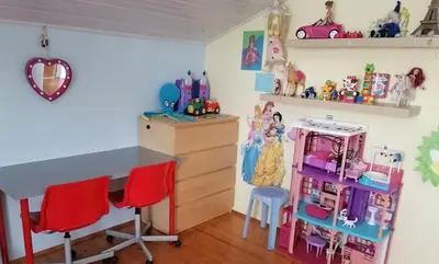 a childs bedroom with a desk and a doll house at at Marian's place in Spuhlja