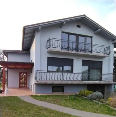a white house with a balcony and a driveway at at Marian's place in Spuhlja