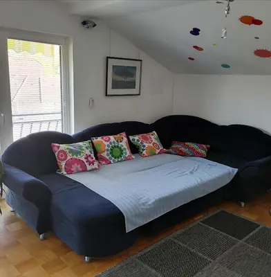a blue couch with pillows in a living room at at Marian's place in Spuhlja