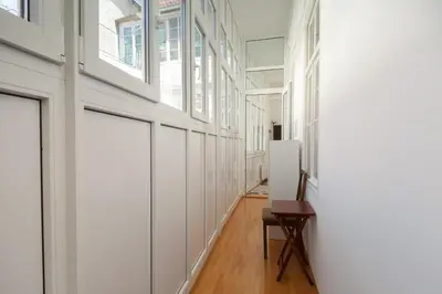 a hallway with white walls and a table and a chair at Charming apartment Laura Tour As Ljubljana by Town Hall in Ljubljana