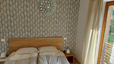 a bedroom with a bed with a headboard and a wall at Apartments Supermjau in Bovec