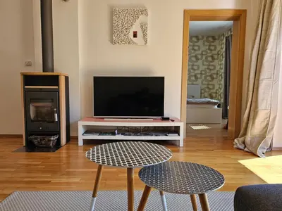 a living room with a television and two stools at Apartments Supermjau in Bovec