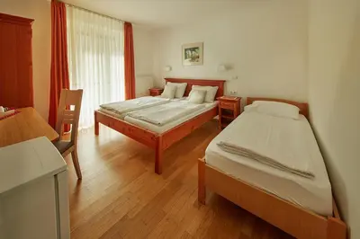 a bedroom with two beds and a window at Rute Hotel and Apartments in Kranjska Gora