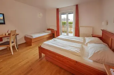 a bedroom with a large bed and a desk and a window at Rute Hotel and Apartments in Kranjska Gora