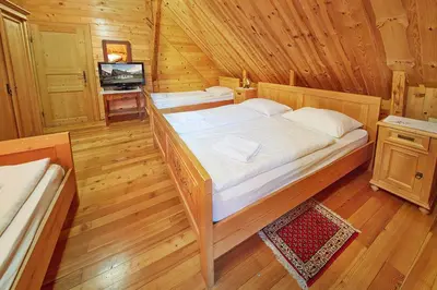 a bedroom with a large bed in a wooden cabin at Rute Hotel and Apartments in Kranjska Gora