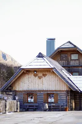 a large wooden building with a balcony on top at Rute Hotel and Apartments in Kranjska Gora