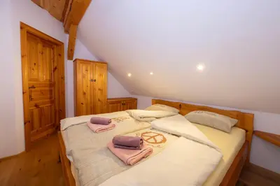 a bedroom with a bed with two towels on it at Apartma in Bungalov Jezerci in Gozd Martuljek