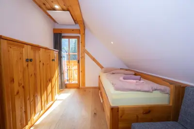 a bedroom with a bunk bed in a attic at Apartma in Bungalov Jezerci in Gozd Martuljek