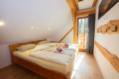 a bedroom with a bed with two dolls on it at Apartma in Bungalov Jezerci in Gozd Martuljek