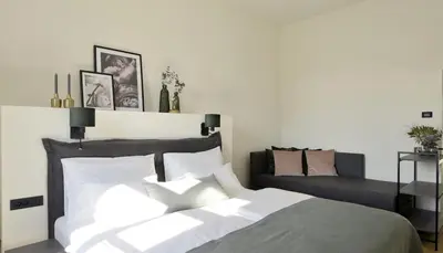 a bedroom with a bed and a couch at Hotel Maribor & Garden Rooms in Maribor