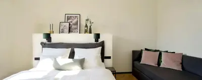 a bedroom with a bed and a couch at Hotel Maribor & Garden Rooms in Maribor